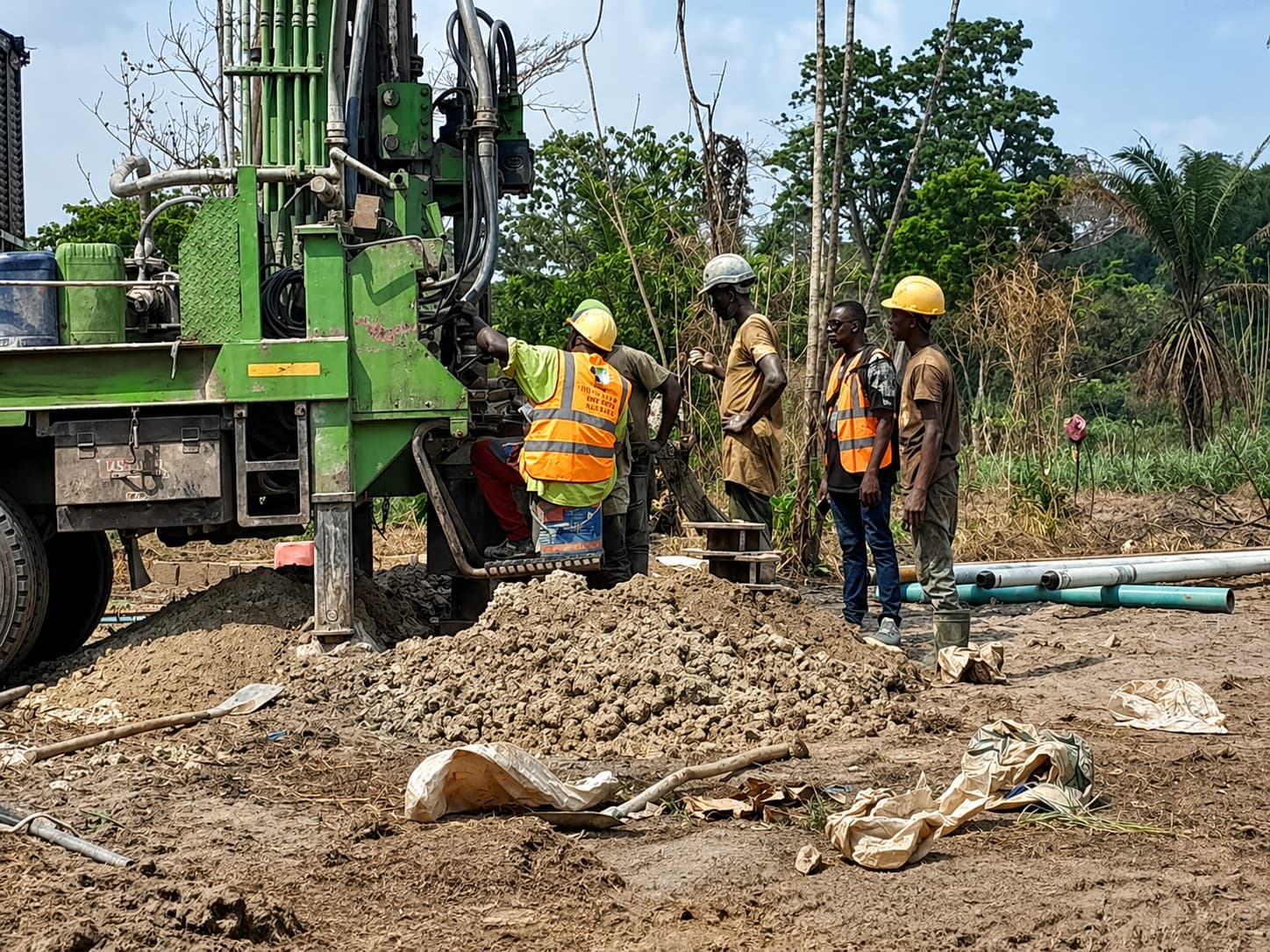Field team and drilling rig testing a groundwater target