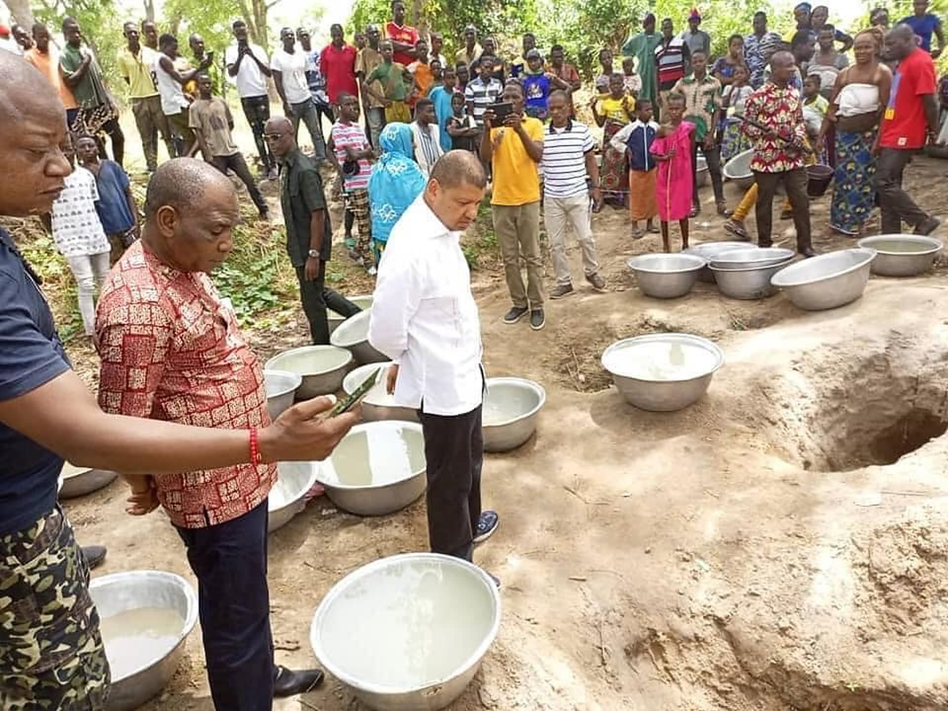 Community members collecting water at a hand-pump water point
